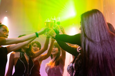 Gençler parti veriyor, içiyor ve dans ediyor.