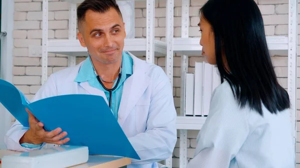 Doutor em uniforme profissional examinando paciente no hospital — Fotografia de Stock