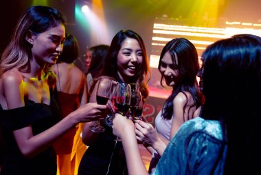 Gençler parti veriyor, içiyor ve dans ediyor.