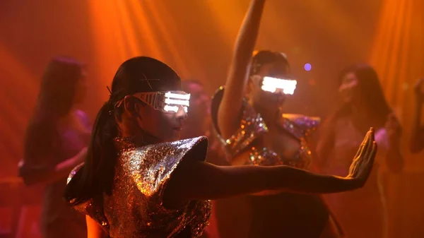 Grupo de personas bailan en discoteca al ritmo de la música de DJ en el escenario — Foto de Stock