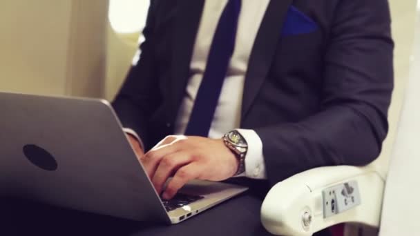Giovane uomo d'affari che utilizza il computer portatile in aereo — Video Stock
