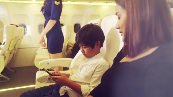 A tripulação da cabina presta serviço à família no avião — Vídeo de Stock