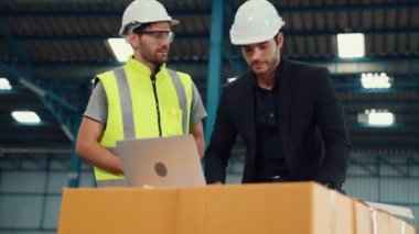 Fabrikada çalışan ve üretim planını tartışan iki fabrika işçisi. .