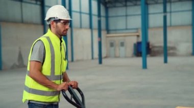 Fabrika işçileri depodaki bir yük arabasında kutu teslimatı yapıyor. .