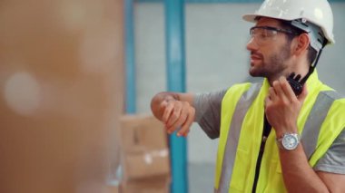 Profesyonel kargo işçisi başka bir işçiyle bağlantı kurmak için telsizle konuşuyor.