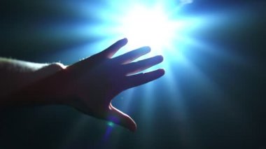 Parlayan ışığı kapatmak için uzanan el.