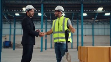 Fabrika işçileri depodaki bir yük arabasında kutu teslimatı yapıyor. .