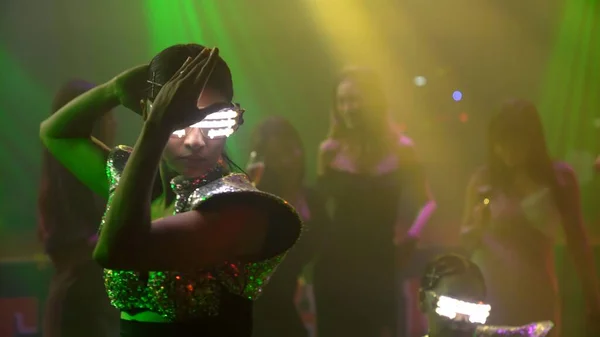 Grupo de personas bailan en discoteca al ritmo de la música de DJ en el escenario — Foto de Stock