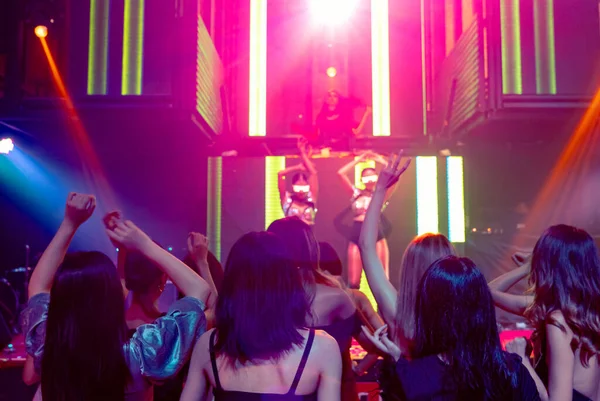 Grupo de personas bailan en discoteca al ritmo de la música de DJ en el escenario — Foto de Stock