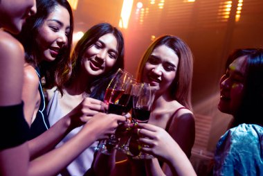 Gençler parti veriyor, içiyor ve dans ediyor.