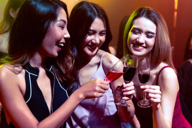 Gençler parti veriyor, içiyor ve dans ediyor.