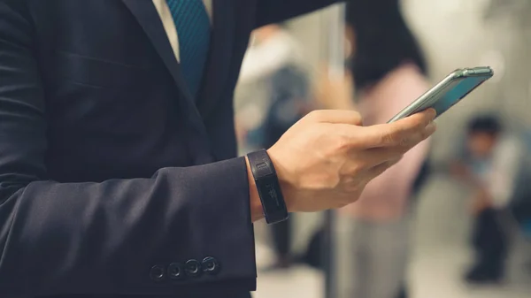 Uomo d'affari che utilizza il telefono cellulare sul treno pubblico — Foto Stock