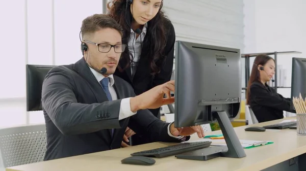 Zakenmensen met een koptelefoon aan het werk — Stockfoto