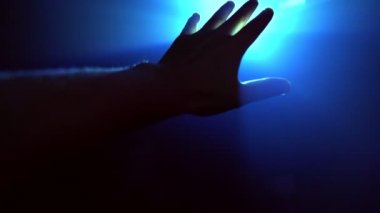 Parlayan ışığı kapatmak için uzanan el.