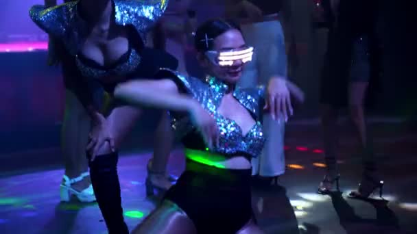 Group of people dance in disco night club to the beat of music from DJ on stage — Stock Video