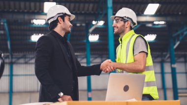 Fabrikada çalışan ve üretim planını tartışan iki fabrika işçisi. .