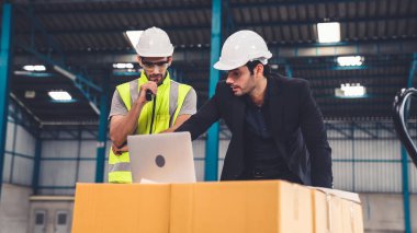 Fabrikada çalışan ve üretim planını tartışan iki fabrika işçisi. .