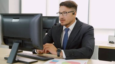 Ofiste çalışan kulaklık takan iş adamları.