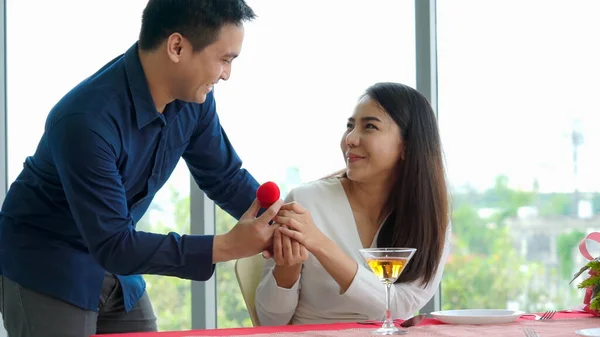 Romantic couple giving gift to lover at restaurant — Stock Photo, Image