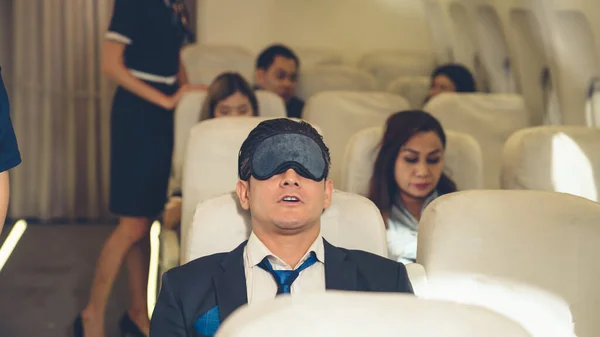 Un hombre de negocios soñoliento viaja en un viaje de negocios en avión — Foto de Stock