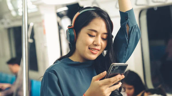 Jeune femme utilisant un téléphone portable dans le train public — Photo