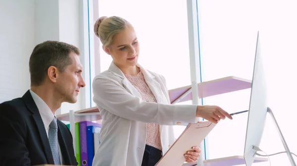 Two business people talk project strategy at office