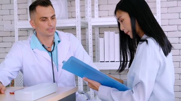 Doutor em uniforme profissional examinando paciente no hospital — Fotografia de Stock