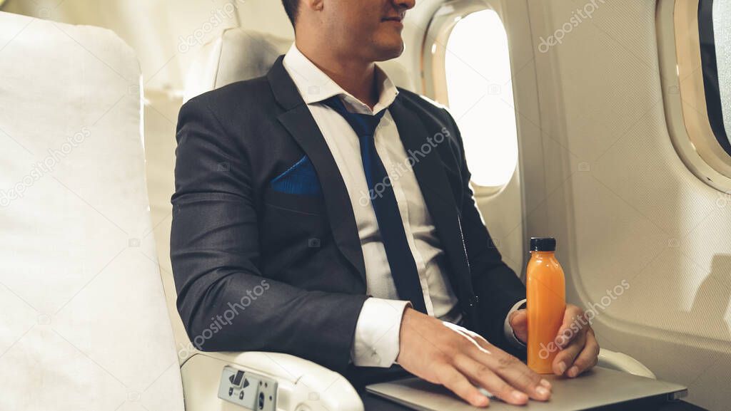 Businessman have orange juice served by an air hostess in airplane
