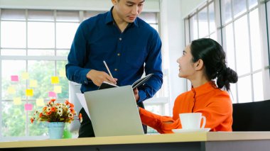 İki iş adamı ofiste proje stratejisi hakkında konuşuyor