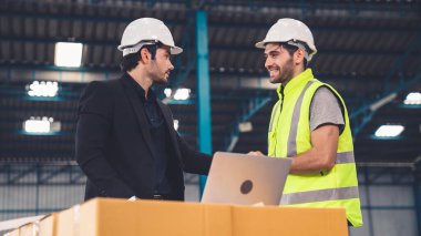 Fabrikada çalışan ve üretim planını tartışan iki fabrika işçisi. .