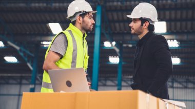 Fabrikada çalışan ve üretim planını tartışan iki fabrika işçisi. .