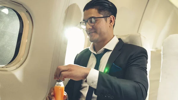Empresario tiene jugo de naranja servido por una azafata en avión — Foto de Stock