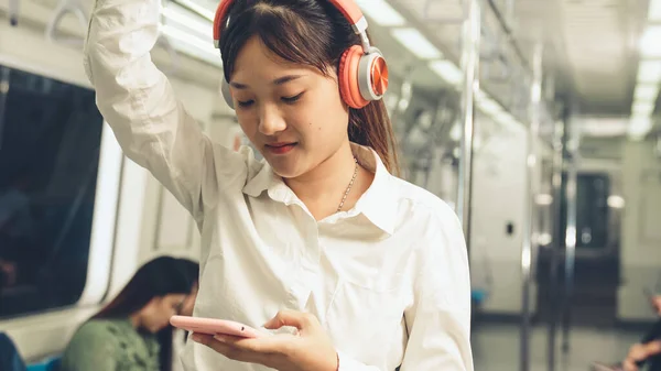 Jeune femme utilisant un téléphone portable dans le train public — Photo