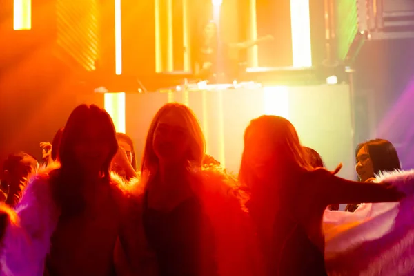 Silhouet beeld van mensen dansen in disco nachtclub op muziek van DJ op het podium — Stockfoto