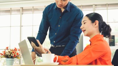 İki iş adamı ofiste proje stratejisi hakkında konuşuyor