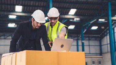 Fabrikada çalışan ve üretim planını tartışan iki fabrika işçisi. .