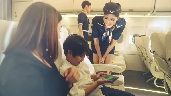 Cabin crew provide service to family in airplane — Stock Photo, Image