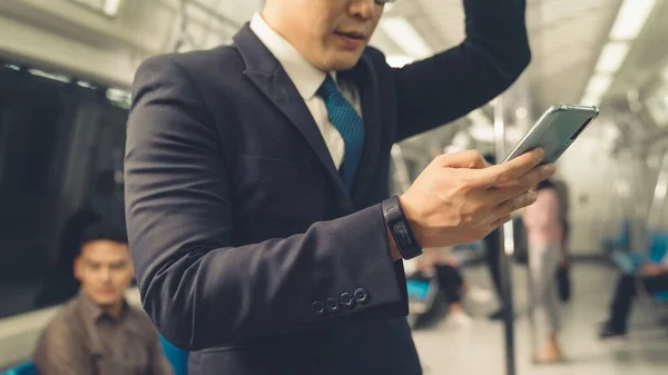 Uomo d'affari che utilizza il telefono cellulare sul treno pubblico — Foto Stock