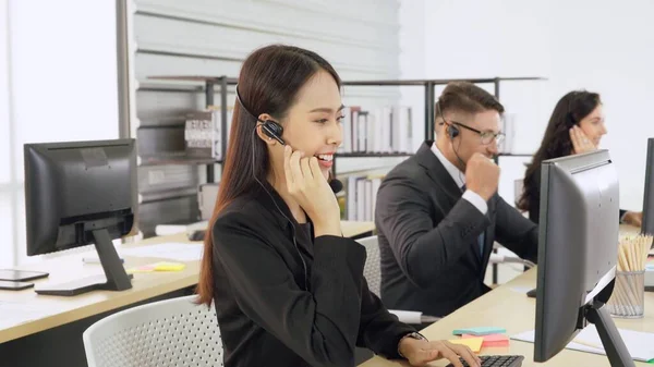 Zakenmensen met een koptelefoon aan het werk — Stockfoto