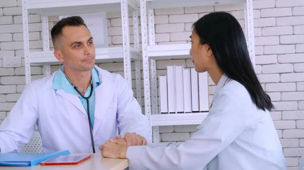 Doutor em uniforme profissional examinando paciente no hospital — Fotografia de Stock