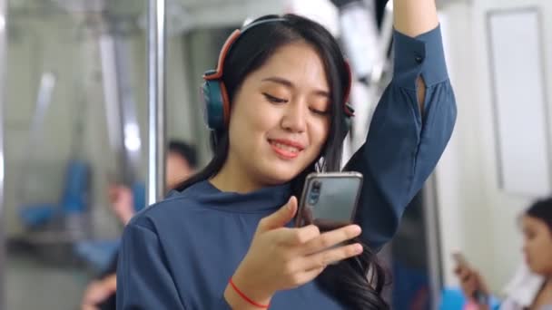 Młoda kobieta korzystająca z telefonu komórkowego w pociągu publicznym — Wideo stockowe