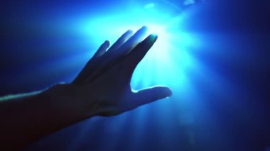 Parlayan ışığı kapatmak için uzanan el.