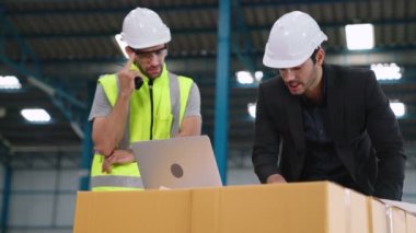 Fabrikada çalışan ve üretim planını tartışan iki fabrika işçisi. .