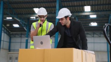 Fabrikada çalışan ve üretim planını tartışan iki fabrika işçisi. .