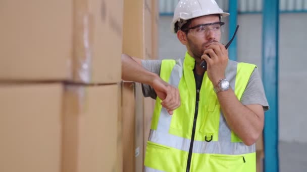 Профессиональный грузовой рабочий говорит по портативному радио, чтобы связаться с другим работником — стоковое видео