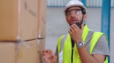 Profesyonel kargo işçisi başka bir işçiyle bağlantı kurmak için telsizle konuşuyor.
