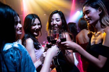 Gençler parti veriyor, içiyor ve dans ediyor.