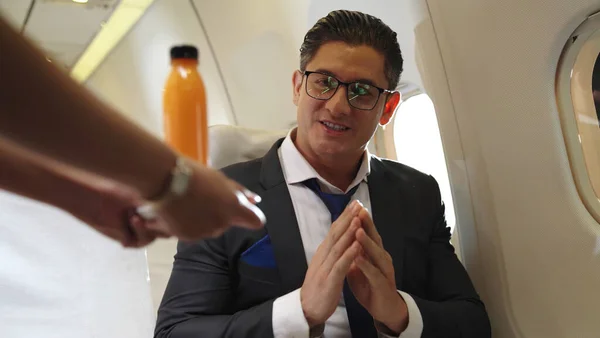 Podnikatel má pomerančovou šťávu podávanou letuškou v letadle — Stock fotografie