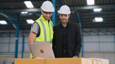 Fabrikada çalışan ve üretim planını tartışan iki fabrika işçisi. .