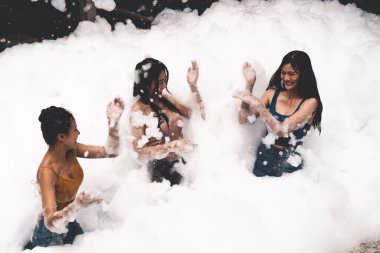 Eğlence ve neşeyle kabarcık havuzunda oynayan kız